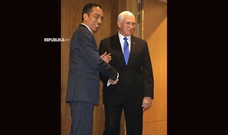 Presiden Joko Widodo (kiri) berjabat tangan dengan Wapres AS Mike Pence sebelum melakukan pertemuan bilateral di sela KTT ASEAN di Pusat Konvensi Suntec, Singapura, Rabu (14/11/2018).