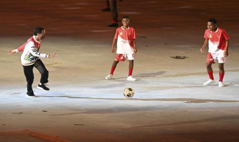 Presiden Joko Widodo (kiri) bermain bola dengan sejumlah pengisi acara saat Upacara Pembukaan PON Papua di Stadion Lukas Enembe, Kompleks Olahraga Kampung Harapan, Distrik Sentani Timur, Kabupaten Jayapura, Papua, Sabtu (2/10/2021). 