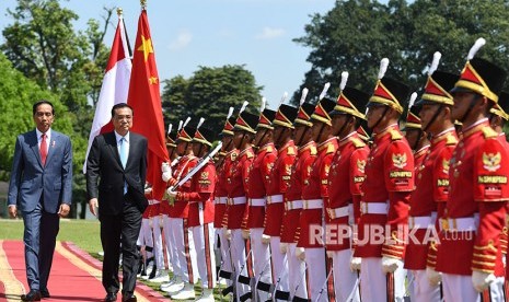 Presiden Joko Widodo (kiri) bersama Perdana Menteri Cina Li Keqiang memeriksa pasukan saat kunjungan kenegaraan di Istana Bogor, Jawa Barat, Senin (7/5).