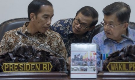 Presiden Joko Widodo (kiri) dan Wapres Jusuf Kalla (kanan) berbincang dengan Seskab Pramono Anung (tengah) sebelum memimpin rapat kabinet terbatas bidang ekonomi di Kantor Kepresidenan, Jakarta, Senin (12/10).