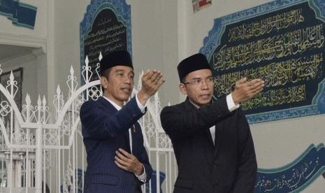 Presiden Joko Widodo (kiri) didampingi Gubernur NTB, TGB Zainul Majdi (kanan), berziarah di makam Pahlawan Nasional Maulana Syekh TGKH Muhammad Zainuddin Abdul Majid di Ponpes NW Pancor, Lombok Timur, NTB, Kamis (23/11). 