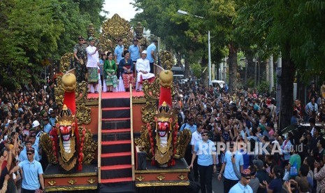 Presiden Joko Widodo (kiri) didampingi Ibu Negara Iriana Joko Widodo (kedua kiri), Gubernur Bali I Made Mangku Pastika (kanan) dan istri Ni Made Ayu Putri mengikuti Pawai Pesta Kesenian Bali ke-40 di Denpasar, Bali, Sabtu (23/6). 