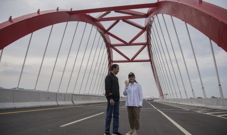 Presiden Joko Widodo (kiri) didampingi Ibu Negara Iriana Joko Widodo (kanan) menyempatkan diri untuk berfoto usai meresmikan pengoperasian tujuh ruas jalan tol Trans Jawa di Jembatan Kalikuto, Kendal, Jawa Tengah, Kamis (20/12/2018).