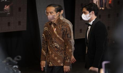 Presiden Joko Widodo (kiri) didampingi Ketua Komite Festival Film Indonesia (FFI) Reza Rahardian (kanan) menghadiri malam penganugerahan FFI 2021, di Jakarta, Rabu (10/11/2021).