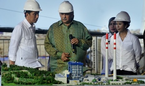 Presiden Joko Widodo (kiri) didampingi Menteri BUMN Rini Soemarno (kanan) dan Bupati Serang Tatu Chasanah (kedua kanan) berbincang dengan Dirut PT PLN Sofyan Basir (kedua kiri) saat meninjau lokasi proyek PLTU (Pembangkit Listrik Tenaga Uap) di Desa Terate, Serang, Banten, Kamis (5/10). 