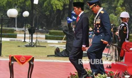 Presiden Joko Widodo (kiri) didampingi Panglima TNI Marsekal TNI Hadi Tjahjanto meninggalkan podium seusai menjadi Inspektur upacara HUT ke-73 TNI di Mabes TNI Cilangkap, Jakarta, Jumat (5/10).