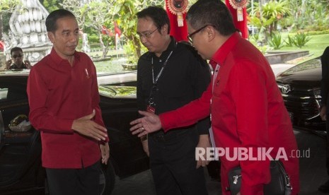 Presiden Joko Widodo (kiri) disambut oleh Sekjen DPP PDIP Hasto Kristiyanto (kanan) dan Panitia Pengarah Rakernas PDIP Prananda Prabowo dalam pembukaan Rakernas III PDIP di Sanur, Bali, Jumat (23/2).