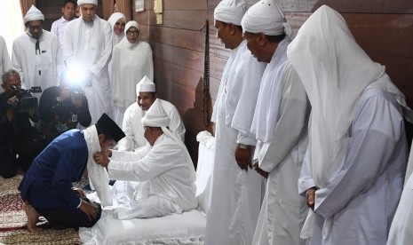 Presiden Joko Widodo (kiri) menerima sorban dari pengasuh Ponpes Babussalam Syekh Haji Hasyim Al-Syarwani Tuan Guru Babussalam di Langkat, Sumatra Utara, Sabtu (29/12/2018).