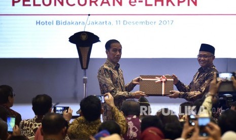 Presiden Joko Widodo (kiri) menerima user name dan password e-LHKPN dari Ketua KPK Agus Rahardjo di sela-sela Pembukaan Konferensi Nasional Pemberantasan Korupsi ke-12, sekaligus Peringatan Hari Anti Korupsi Sedunia Tahun 2017 serta Peluncuran Aplikasi e-LHKPN, di Jakarta, Senin (11/12).