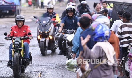 Presiden Joko Widodo (kiri) mengendarai motor menuju Pasar Anyar, Tangerang, Banten, Ahad (4/11/2018). 