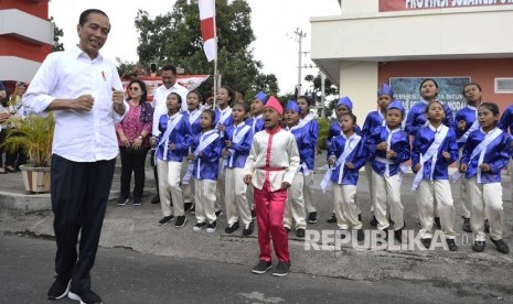 Presiden Joko Widodo (kiri) mengikuti gerakan tari anak-anak saat meninjau Kawasan Ekonomi Khusus (KEK) Bitung di Sulawesi Utara, Jumat (5/7/2019).