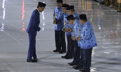 President Joko Widodo (left) hands over Korpri Award during the celebration of the 47th anniversary of the Civil Servant Corps, Jakarta, Thursday.