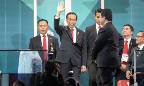 Presiden Joko Widodo melambaikan tangan ke arah penonton saat pembukaan Asian Games ke-18 tahun 2018 di Stadion Utama Gelora Bung Karno , Senayan, Jakarta, Sabtu (18/8). 