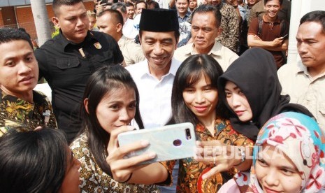 Presiden Joko Widodo melayani jamaah masjid Nurul Barkah berswafoto usai melaksanakan Salat Jumat disela sidak runway 3 di Bandara Soekarno Hatta, Tangerang, Banten, Jumat (21/6/2019).