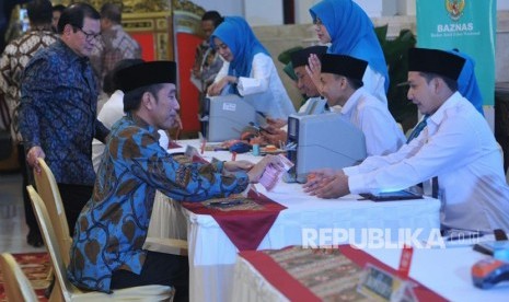 Presiden Joko Widodo membayar zakat penghasilan melalui Baznas di Istana Merdeka, Jakarta, Kamis (16/5).