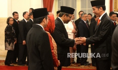 Presiden Joko Widodo memberikan selamat kepada Mahfud MD usai pengambilan sumpah saat pelantikan Unit Kerja Presiden bidang Pembinaan Ideologi Pancasila (UKP-PIP) di Istana Negara, Jakarta, Rabu (7/6).