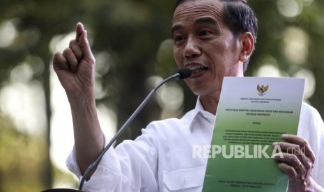 Presiden Joko Widodo memperlihatkan Surat Keputusan (SK) perhutanan sosial saat menghadiri penyerahan Surat Keputusan tersebut di taman hutan wisata punti kayu Palembang, Sumatera Selatan, Ahad (25/11/2018).