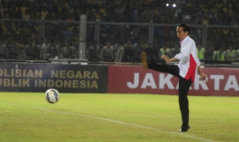 Presiden Joko Widodo menendang bola saat membuka laga final Piala Bhayangkara antara Persib Bandung dengan Arema Cronus di Stadion Utama Gelora Bung Karno, Jakarta, Ahad (3/4). 