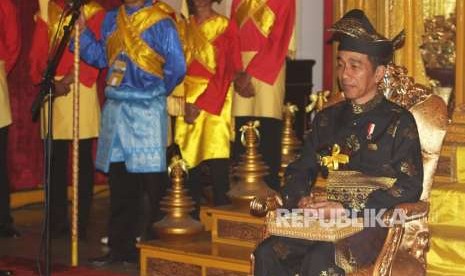 Presiden Joko Widodo mengenakan pakaian adat Melayu Deli saat mengikuti prosesi pemberian gelar adat Melayu Deli, di Istana Maimun, Medan, Sumatera Utara, Ahad (7/10). 