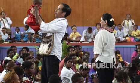 Presiden Joko Widodo menggendong seorang anak saat kunjungan kerja di Distrik Agats, Kabupaten Asmat, Papua, Kamis (12/4). 