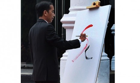 Presiden Joko Widodo menggoreskan tinta saat membuka pameran lukisan koleksi Istana dalam pameran 17l71 di Galeri Nasional, Jakarta, Senin (1/8)