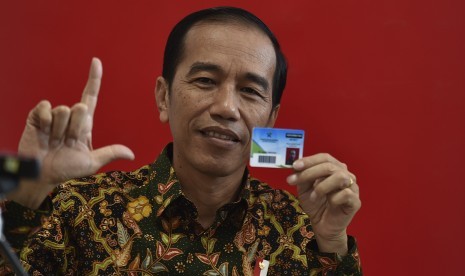 Presiden Joko Widodo menunjukkan kartu keanggotaan Perpustakaan Nasional disela peresmian di Jakarta, Kamis (14/9).