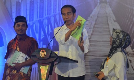 Presiden Joko Widodo menunjukkan sertifikat tanah 