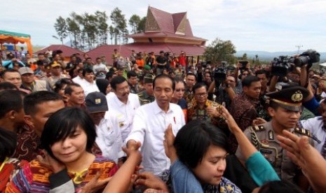 Presiden Joko Widodo menyapa warga saat tiba di kawasan perumahan relokasi pengungsi Gunung Sinabung di Desa Siosar, Karo, Sumatra Utara, Sabtu (14/10). Perumahan untuk relokasi pengungsi Sinabung yang dipersiapkan sebanyak 370 rumah baru itu akhirnya selesai dan telah dihuni oleh para pengungsi. 