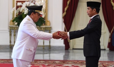 Presiden Joko Widodo menyerahkan petikan keputusan kepada Gubernur Lampung terpilih Arinal Djunaidi sebelum prosesi pelantikan di Istana Merdeka, Jakarta, Rabu (12/6/2019). 