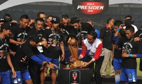 Presiden Joko Widodo menyerahkan piala kepada kesebelasan Persib seusai laga final Piala Presiden di Stadion Utama Gelora Bung Karno, Ahad (18/10).Republika/Edwin Dwi Putranto