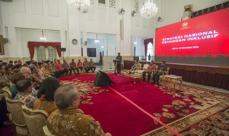 Presiden Joko Widodo (podium) menyampaikan sambutannya pada acara peluncuran Strategi Nasional Keuangan Inklusif di Istana Negara, Jakarta, Jumat (18/11). 