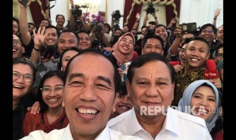 Presiden Joko Widodo saat berswafoto dengan Ketum Gerindra Prabowo Subianto bersama awak media usai melakukan konferensi pers bersama di Istana Merdeka, Jakarta, Jumat (11/10)