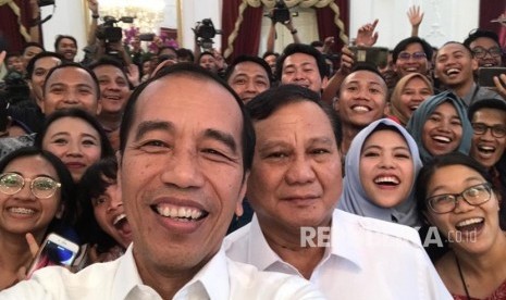 Presiden Joko Widodo saat berswafoto dengan Ketum Gerindra Prabowo Subianto bersama awak media usai melakukan konferensi pers bersama di Istana Merdeka, Jakarta, Jumat (11/10)