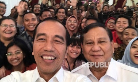 Presiden Joko Widodo saat berswafoto dengan Ketum Gerindra Prabowo Subianto bersama awak media usai melakukan konferensi pers bersama di Istana Merdeka, Jakarta, Jumat (11/10)