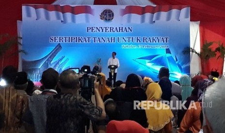 Presiden Joko Widodo saat menyerahkan sertifikat tanah gratis di Lapangan Makkatang Daeng Sibali, Takalar, Makassar, Sulawesi Selatan, Kamis siang (15/2).