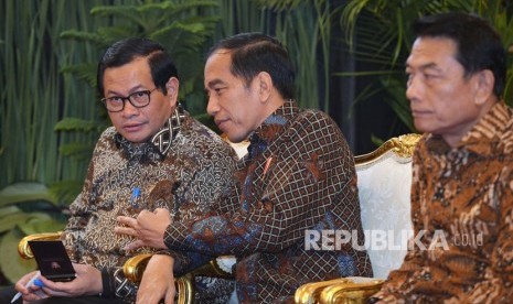 Presiden Joko Widodo (tengah) berbicara dengan Sekretaris Kabinet Pramono Anung (kiri) dan Kepala Staf Presiden Moeldoko (kanan). 