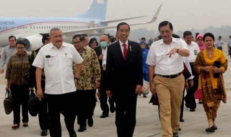 Presiden Joko Widodo (tengah) berbincang dengan Menkopolhukam Luhut Pandjaitan (dua kanan) dan Gubernur Sumatra Selatan saat menuju VIP Bandara Sultan Mahmud (SMB) II, Palembang, Sumsel, Kamis (29/10). 