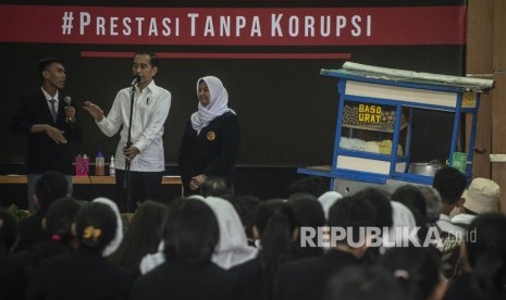 Presiden Joko Widodo (tengah) berbincang dengan murid seusai menyaksikan drama bertajuk Prestasi Tanpa Korupsi di SMKN 57 Jakarta, Jakarta Selatan, Senin (9/12/2019).