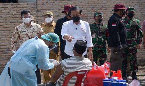 Presiden Joko Widodo (tengah) berbincang dengan warga saat meninjau pelaksanaan vaksinasi COVID-19 dari pintu ke pintu (door to door) di Desa Emplasemen, Kecamatan Beringin, Kabupaten Deliserdang, Sumatera Utara, Kamis (16/9/2021). Dalam kunjungan tersebut Presiden Joko Widodo menyaksikan secara langsung pelaksanaan vaksinasi yang dilakukan secara jemput bola atau dari rumah ke rumah sehingga dapat mempercepat program vaksinasi COVID-19.