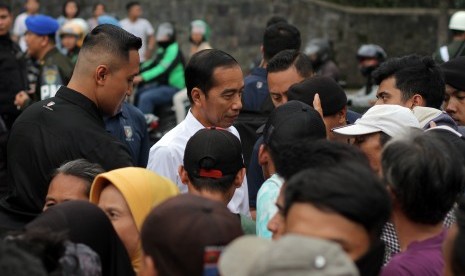 Presiden Joko Widodo (tengah) berbincang dengan warga saat pembagian paket sembako di Kelurahan Baranangsiang, Kota Bogor, Jawa Barat, Senin (3/6/2019).