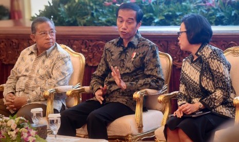 Presiden Joko Widodo (tengah) berdialog dengan Menteri Keuangan Sri Mulyani Indrawati (kanan) serta Menko Perekonomian Darmin Nasution (kiri). 