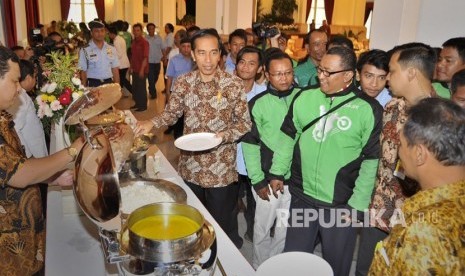 Presiden Joko Widodo (tengah) berdialog dengan pengendara Gojek saat pertemuan makan siang bersama pengemudi kendaraan umum di Istana Negara, Jakarta, Selasa (2/9).