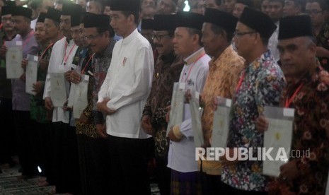 Presiden Joko Widodo (tengah) berfoto bersama para perwakilan penerima sertifikat tanah wakaf usai pembagian di Masjid Baiturrahman, Ngawi, Jawa Timur, Jumat (1/2/2019). 