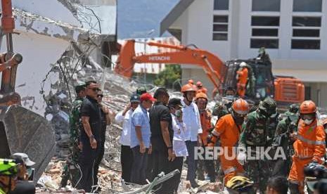 Presiden Joko Widodo (tengah, berhelm) didampingi sejumlah menteri Kabinet Kerja mengawasi proses evakuasi korban gempa di reruntuhan Hotel Roaroa di Palu, Sulawesi Tengah, Rabu (3/10).