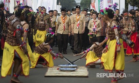 Presiden Joko Widodo (tengah) berjalan bersama Ibu Negara Iriana Joko Widodo (kanan) dan  Ketua Kwartir Nasional Gerakan Pramuka Adhyaksa Dault (kiri) mengikuti prosesi Raimuna Nasional XI 