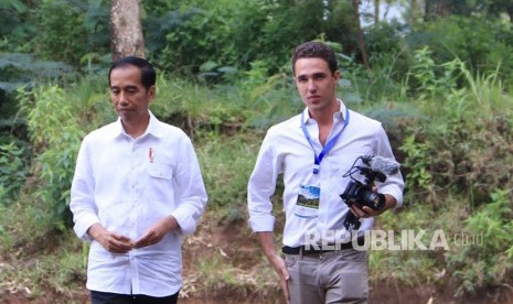 Presiden Joko Widodo tengah bersama Gary Bencheghib (23), warga Perancis pembuat film pendek tentang Sungai Citarum terkotor di dunia yang viral di media sosial dalam kegiatan  Citarum Harum di Situ Cisanti, Kertasari, Kabupaten Bandung, Selasa (22/2). 