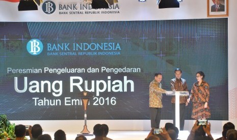 Presiden Joko Widodo (tengah) bersama Gubernur Bank Indonesia (BI) Agus Martowardojo (kiri) serta Menkeu Sri Mulyani Indrawati (kanan) secara simbolis meluncurkan uang rupiah kertas dan logam tahun emisi 2016 di Gedung Bank Indonesia, Jakarta, Senin (19/12