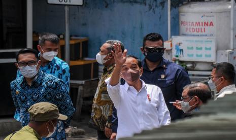 Presiden Joko Widodo (tengah) bersama Gubernur Jawa Barat (kiri) menyapa warga di Pasar Sederhana, Bandung, Jawa Barat, Senin (17/1/2022). Presiden Joko Widodo memberikan paket sembako dan bantuan langsung tunai bagi pedagang pasar, pedagang kaki lima dan pedagang asongan di Pasar Sederhana.