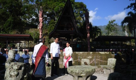 Presiden Joko Widodo (tengah) bersama Ibu Negara Iriana Joko Widodo (kanan) mengunjungi Kampung Adat Batu Persidangan di Samosir, Sumut, Rabu (31/7/2019). Kedatangan Presiden Jokowi itu untuk meninjau pengembangan wisata di kawasan Danau Toba yang akan dijadikan destinasi wisata berkelas dunia. 