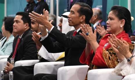 Presiden Joko Widodo (tengah) bersama Ibu Negara Iriana (kanan) dan Ketua INASGOC Erick Thohir (kiri) menghadiri Upacara Pembukaan Asian Games ke-18 Tahun 2018 di Stadion Utama GBK, Senayan, Jakarta, Sabtu Sabtu (18/8).